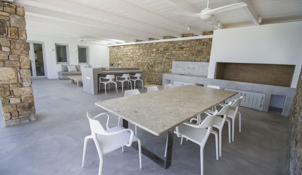outdoor-dining-area-with-stone-walls-and-modern-kitchen