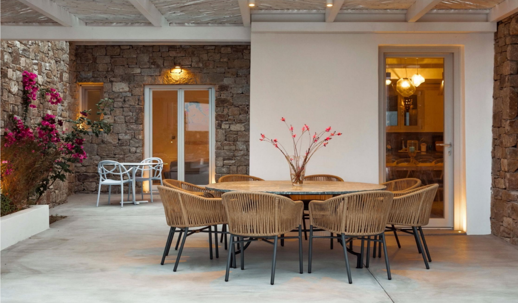 outdoor-dining-table-with-rattan-chairs-and-flowers