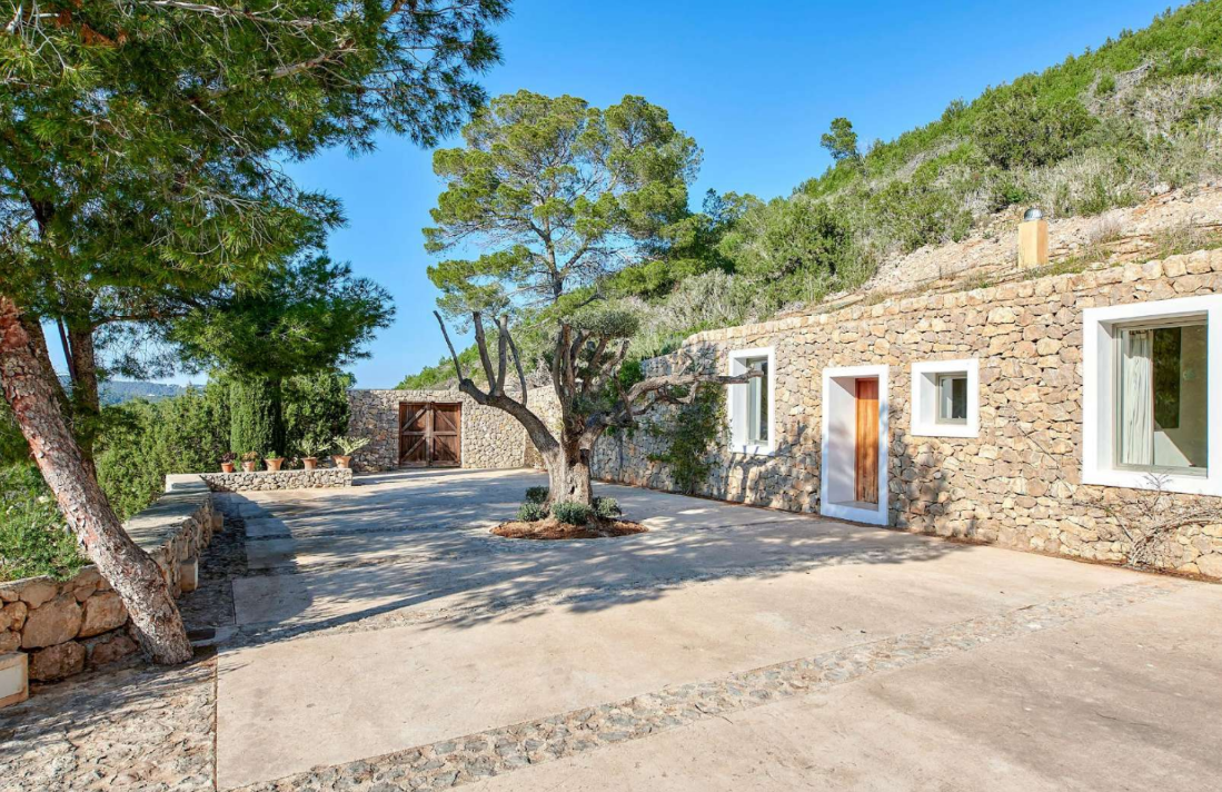 stone-wall-driveway-modern-house-surrounded-by-trees