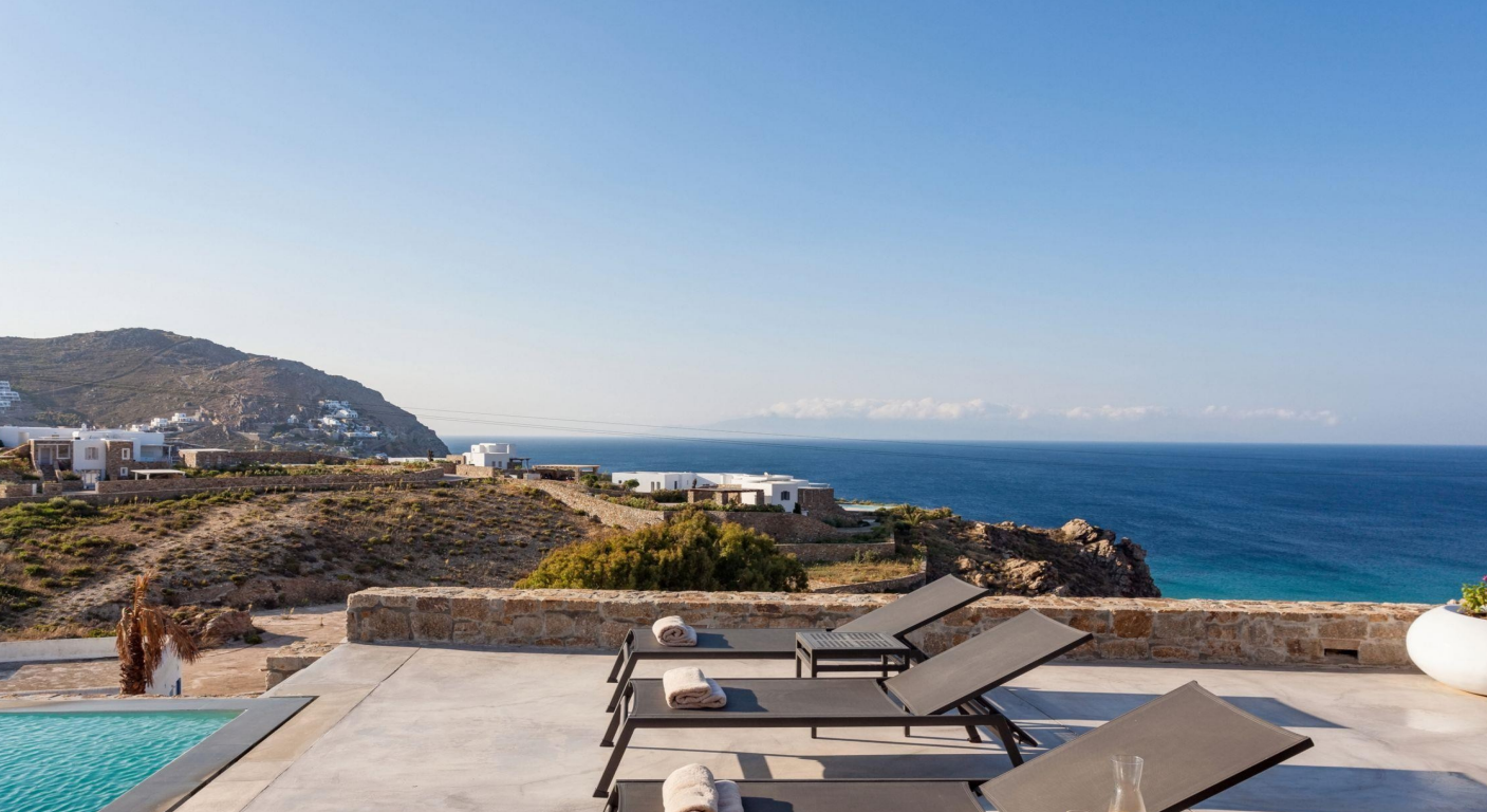 luxury-poolside-loungers-ocean-view-mountain-backdrop