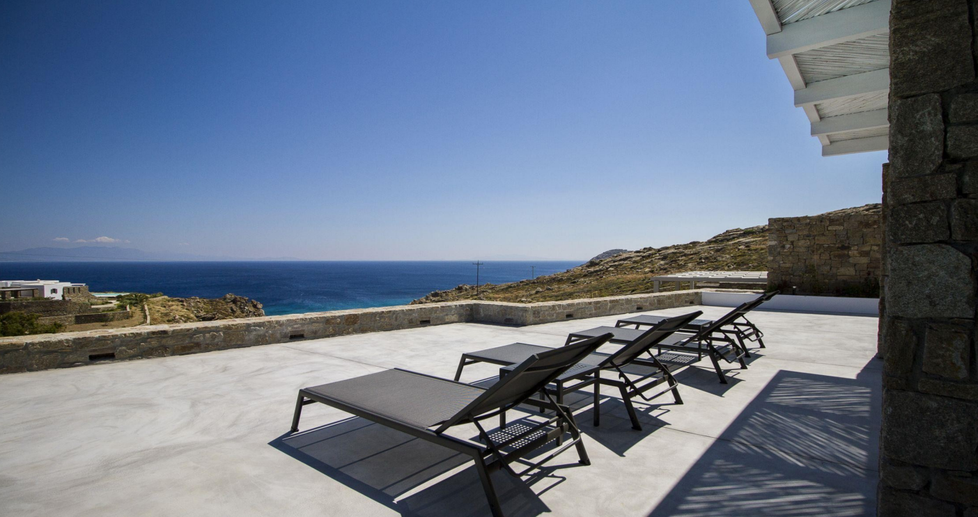 luxury-poolside-loungers-sea-view-mountain-background