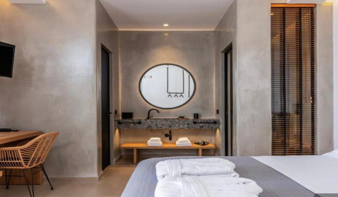 modern-bedroom-with-bathroom-and-round-mirror-with-wooden-details